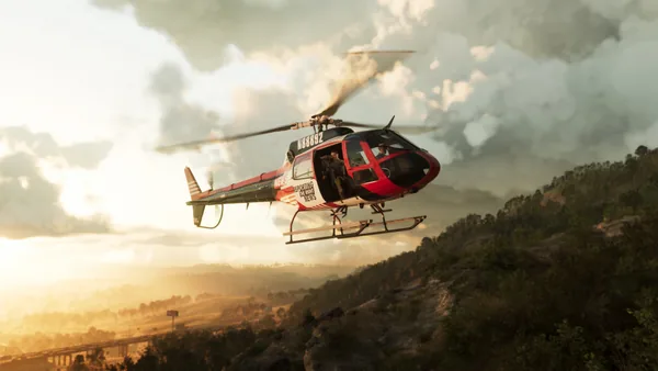 A news helicopter over the ridge, a cameraman filming from the open door.