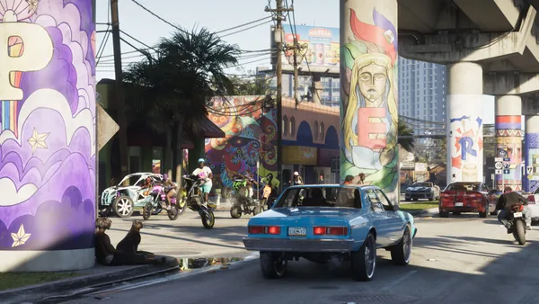 Dirt bikes and ATVs under an overpass painted with murals, a To 97 sign on the right.