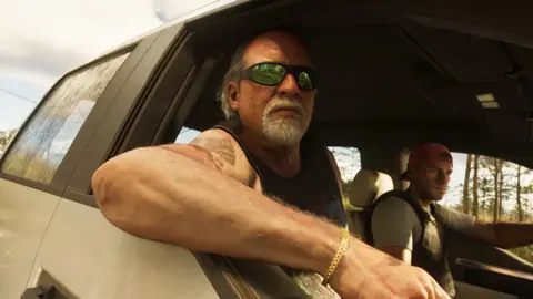 In the passenger seat with an arm out of the window while Jason drives.