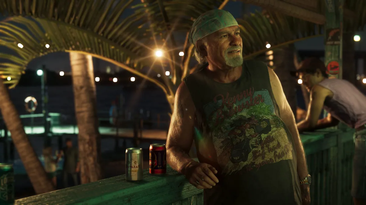 Brian Heder leans on a railing at night under palms and string lights, two cans beside him.