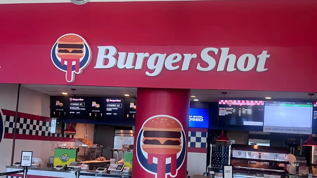 The real-life BurgerShot food stand inside Miami’s Kaseya Center features a red BurgerShot sign, branded pillars and a checkerboard counter.