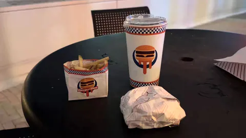 A BurgerShot meal at Miami’s Kaseya Center includes branded fries packaging, a BurgerShot drink cup and a wrapped food item.