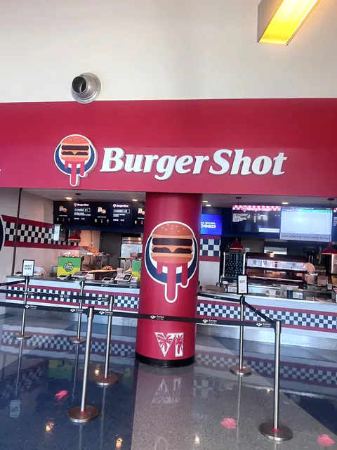 The BurgerShot counter at Miami’s Kaseya Center features the BurgerShot sign, digital menu boards, and a burger-logo pillar marked with a VI palm-tree emblem.