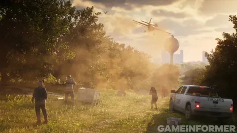 A sunlit field with a low-flying crop plane, a white pickup truck, people walking and a water tower in the distance.