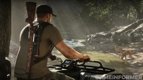 Jason, a rifle on his back, rides an ATV beside a creek where deer are drinking.