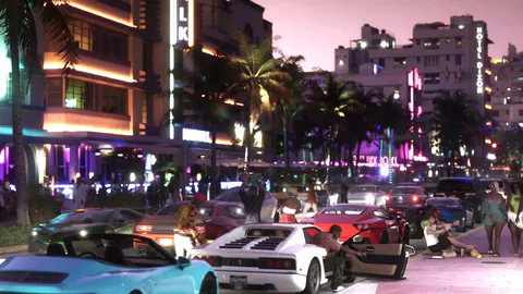 GTA VI screenshot shows a nighttime Vice City street scene with traffic, buildings and neon lights.