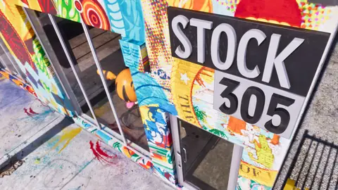 The Stock 305 sign on a storefront covered in murals.
