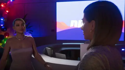 Valentina in the Megamundo lobby, introducing the pair to Petra Navarro (back to camera).
